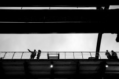 Two silhouetted figures, one pointing, on a huge steal construction