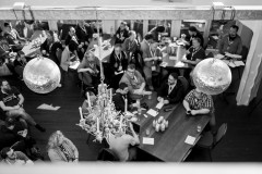 Two mirror balls are suspended from the ceiling over the attendees of BarCamp Ruhr 12