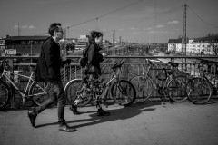 Photographers walking across a bridge above train tracks