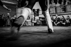 Wrestler Daniel Sparks charging at Fynn Freyhart who's hung up on the ropes