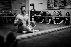 Sitting in the middle of the ring and holding is academy cup trophy, Vinny Vortex celebrates his victory