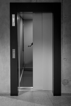 Closing evlevator door, with a hand seen, reaching for the floor buttons