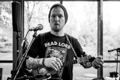 Shane with a surprised look on his face, while tuning his ukulele