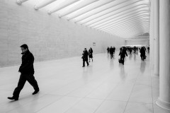 People walking along white marble wall and floor