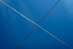 Crossing clothes lines before a clear, blue sky