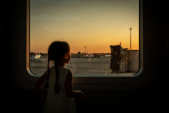 Looking out a window at the airport during sunset