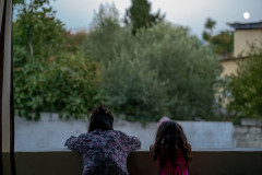 Mother and daughter looking over a wall