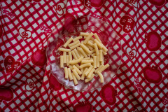 Clear bowl of noddules on a red & white checkered tablecloth