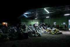 Piles of sacks full of olives waiting to be processed in front of the factory