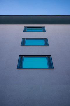 Three windows ontop of each other reflecting the blue sky
