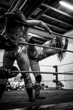 Iva Kolasky is kicking Diana Strong in the corner of the ring