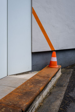 A pylon and an orange line on a wall