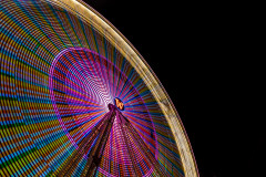 Ferris wheel in blurred motion, covered in colorful lights