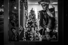 Hairdresser window with tree vertically aligned example images of hair styles on the left, a Christmas tree in the middle and an image of another model on the left