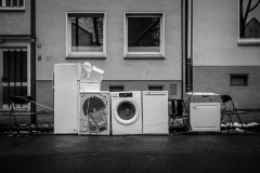 A bunch of white goods (fridge, wasching machine, oven and dishwasher) on the curb