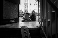 My daugthers sitting at the front door of our house in the morning, waiting for me to get the bike out