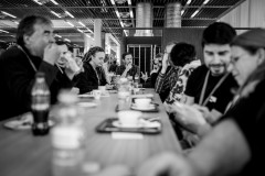 Monochrome image of contributers sitting at a long table