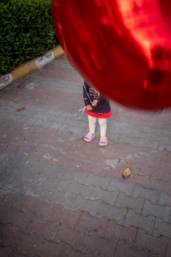 My daugther with her red, heart-shaped ballon, which is hiding her face