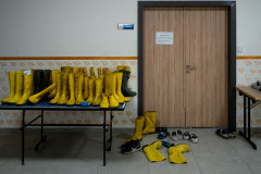 A table full of yellow rubber working boots outside the volunteers' makeshift dormitory.