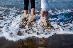 Legs of my wife and daughter in the ocean