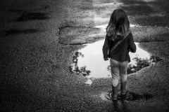 My daugther is about to walk into a puddle, wearing her new rubber boots