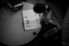 My daugther sitting at the table looking into her math book