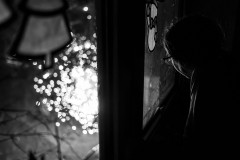 Monochrome image of my daugther watching the fireworks through or kitchen window